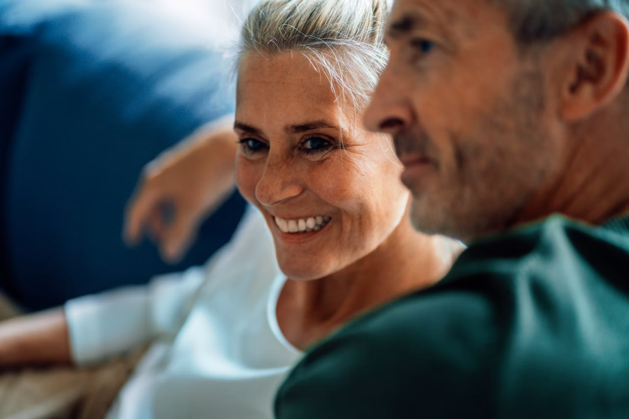 Woman and man sitting together on a sofa indoors